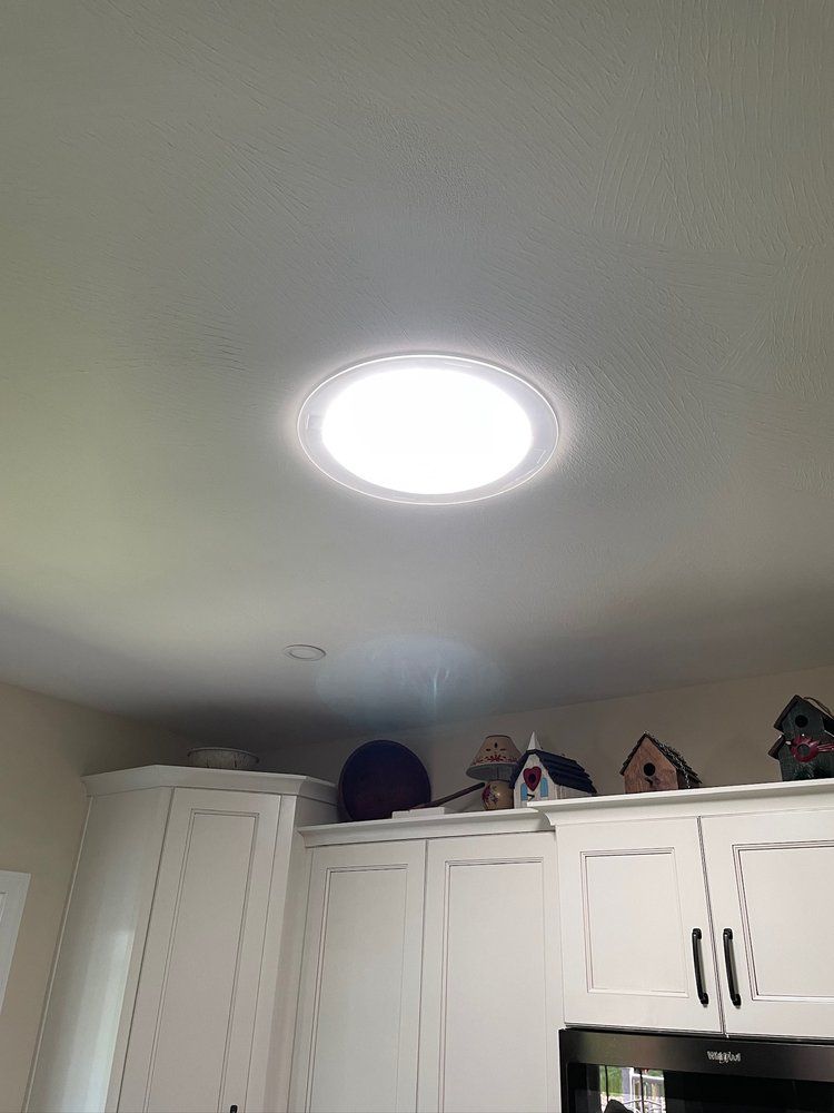 A kitchen with white cabinets and a skylight in the ceiling