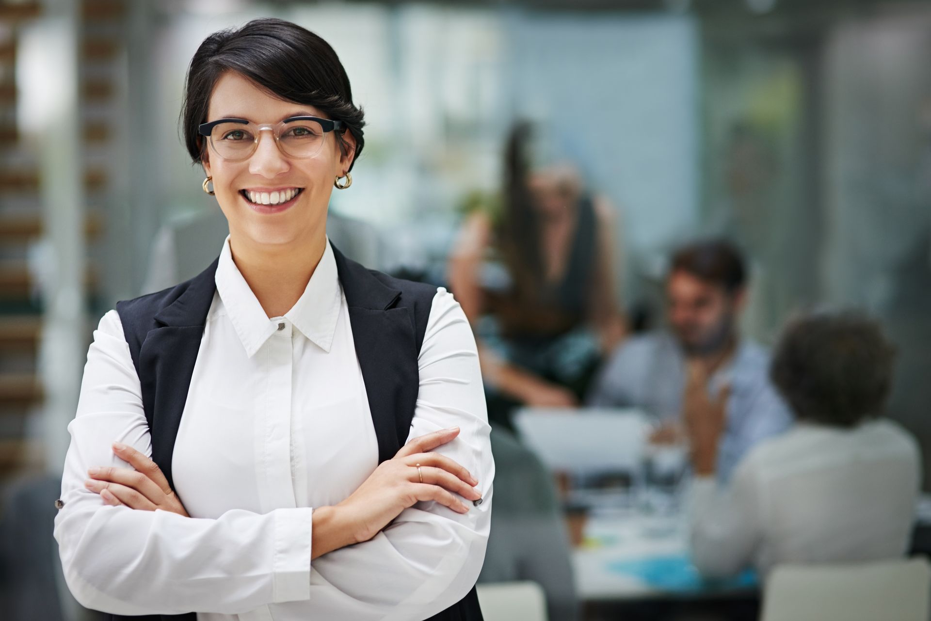 A smiling CPA participates in a meeting, conveying confidence and engagement with her colleagues.