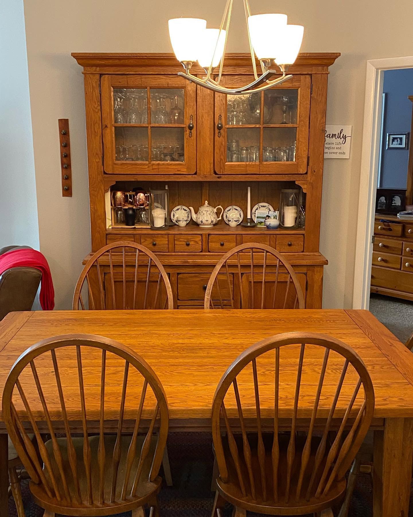 Wooden dining room with table, chairs, hutch, and chandelier.