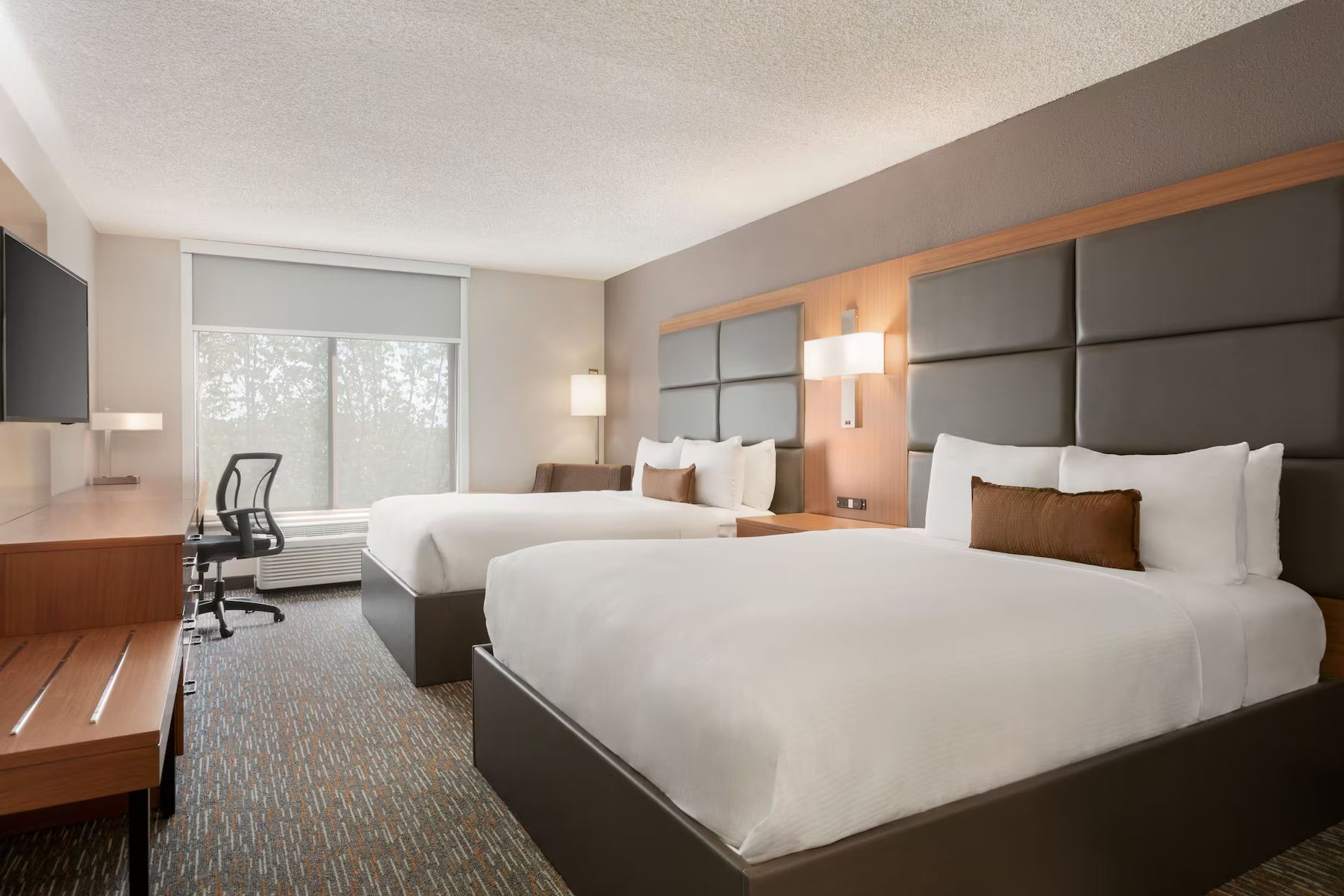 A hotel room with two beds and a desk
