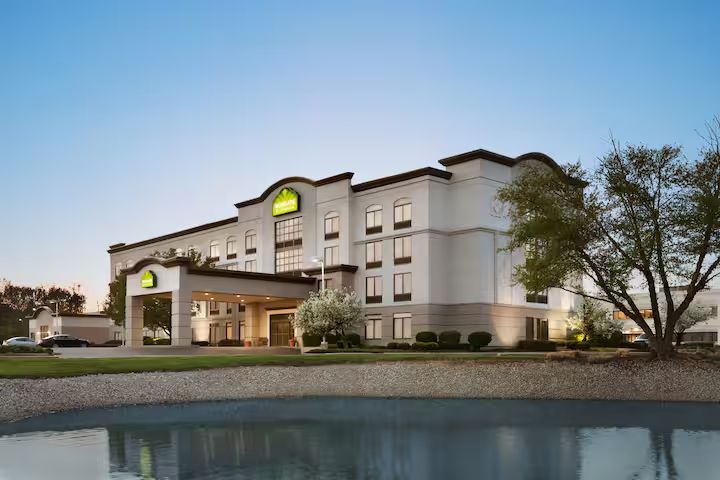 A large hotel with a pond in front of it.
