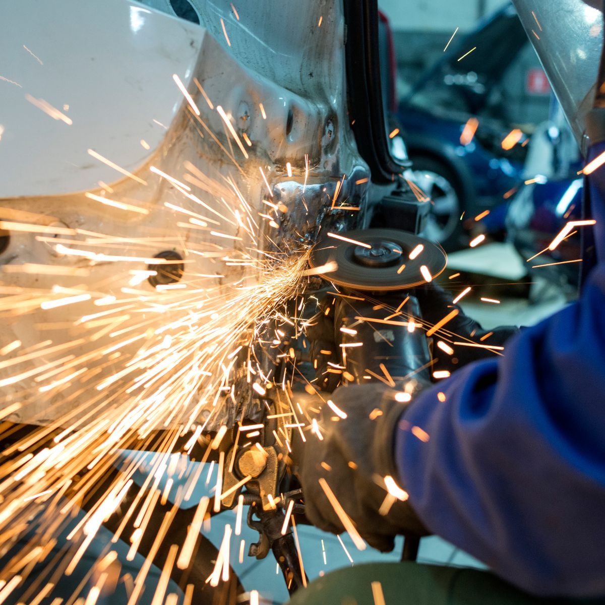 A person is grinding a piece of metal with sparks coming out of it