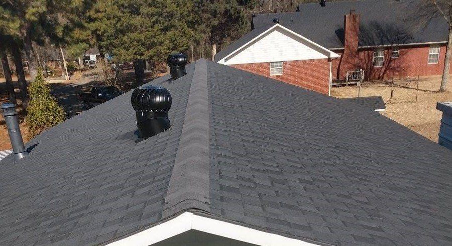 The roof of a house has a black chimney on it