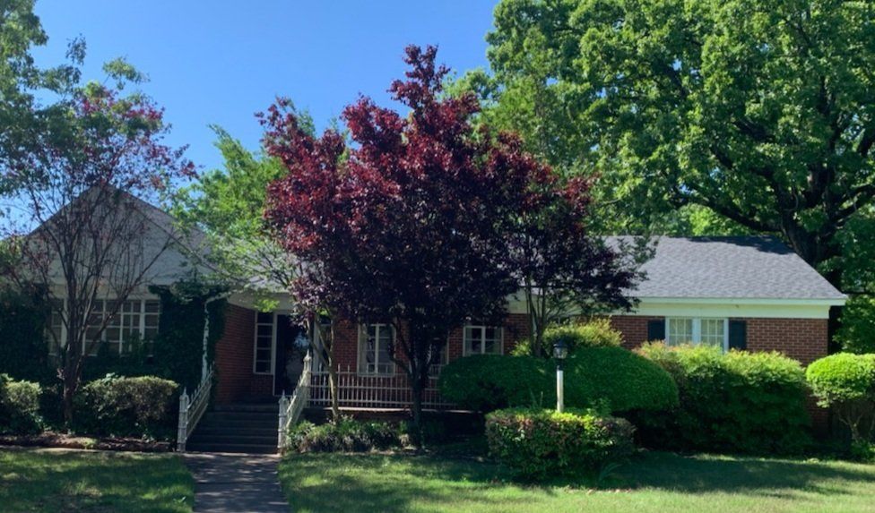 A brick house with a tree in front of it