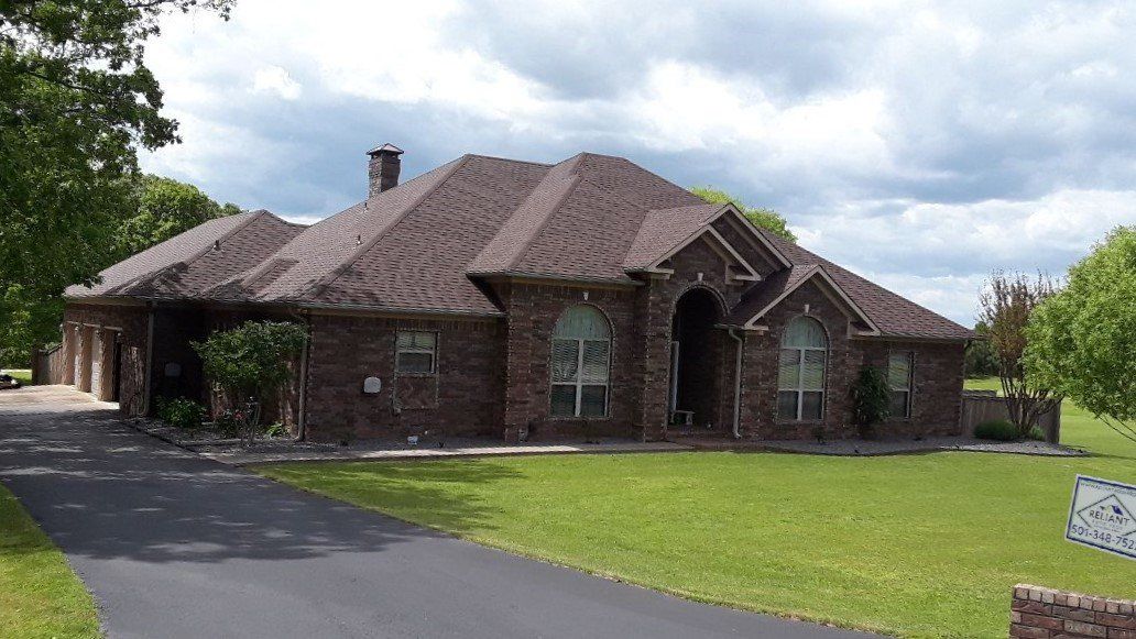 A large brick house with a driveway leading to it