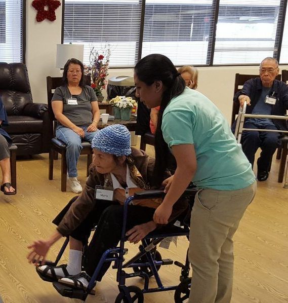 Caregiver supporting kupuna at Oʻahu adult day care facility