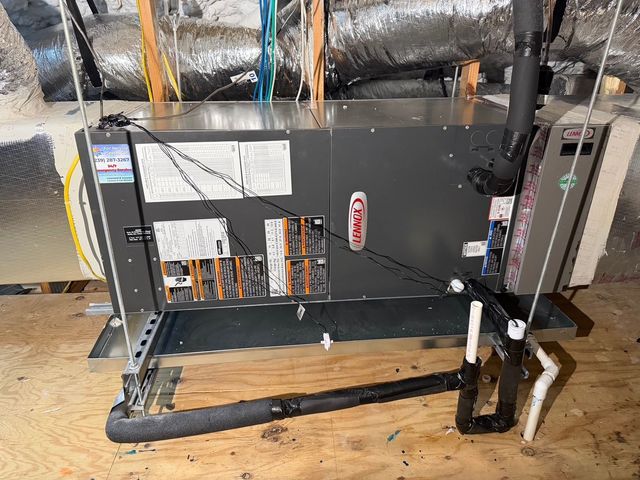Industrial HVAC unit with exposed wires and ductwork in a utility room