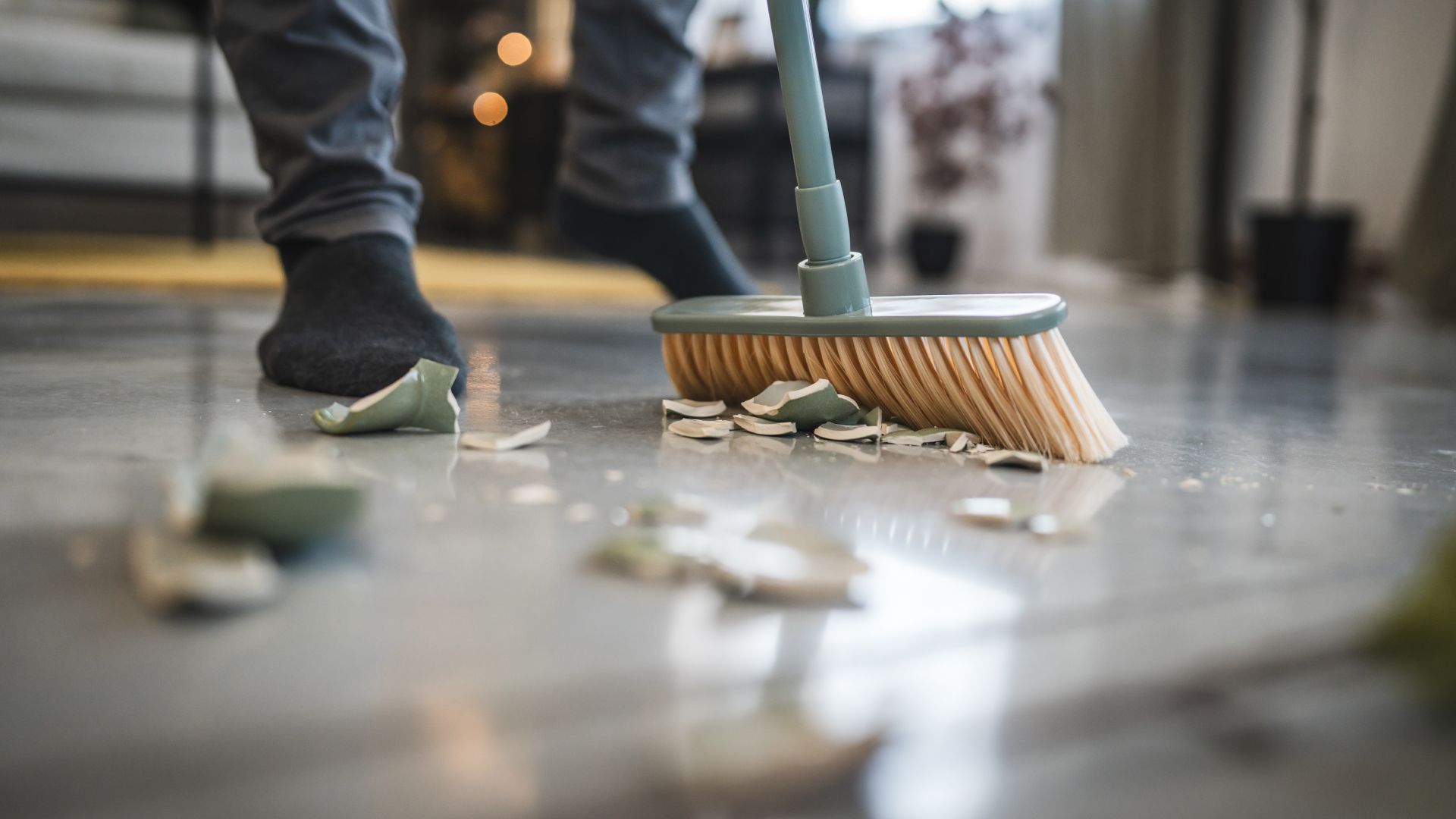 A person is sweeping the floor with a broom.