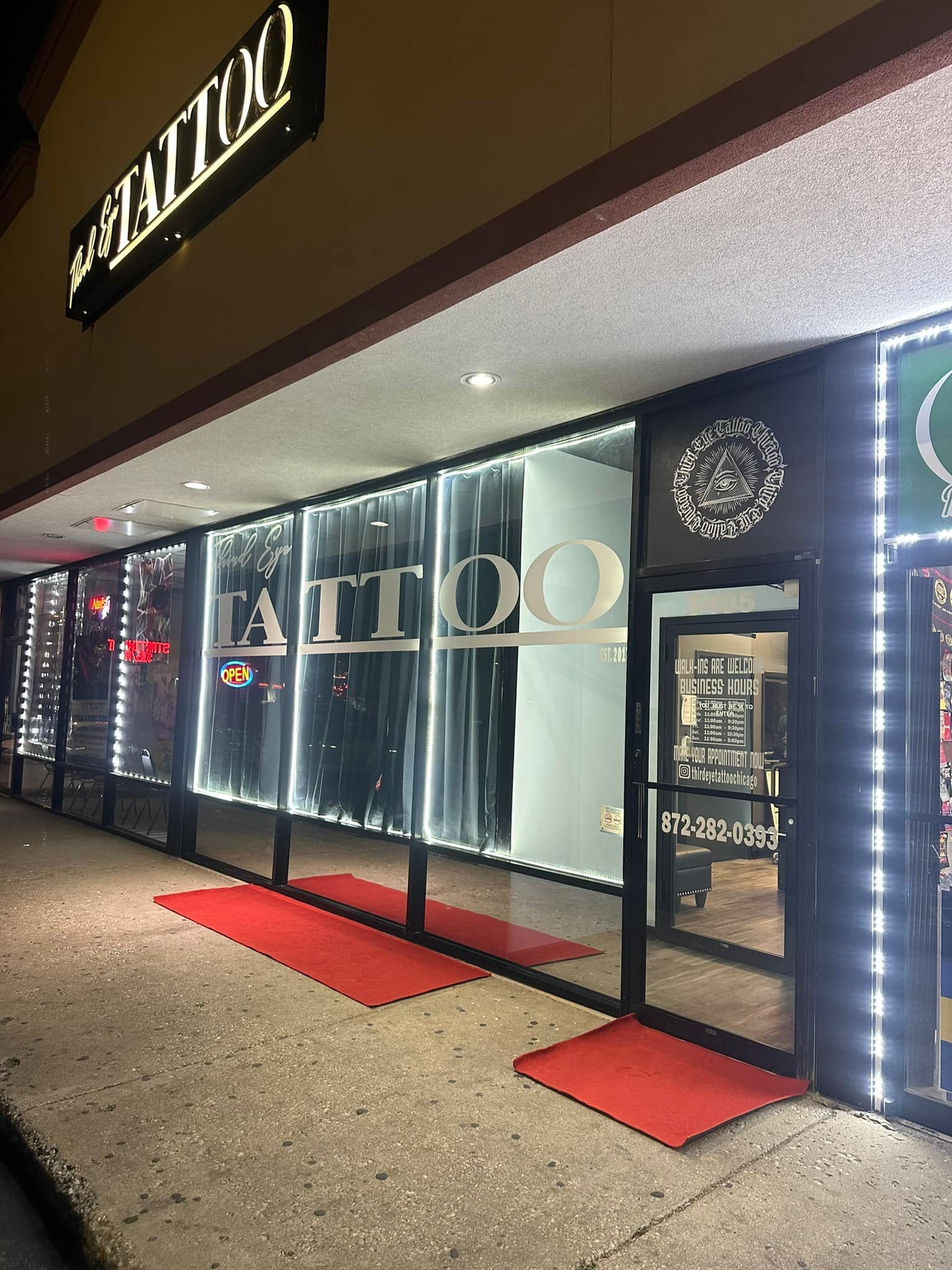 Tattoo shop storefront at night with