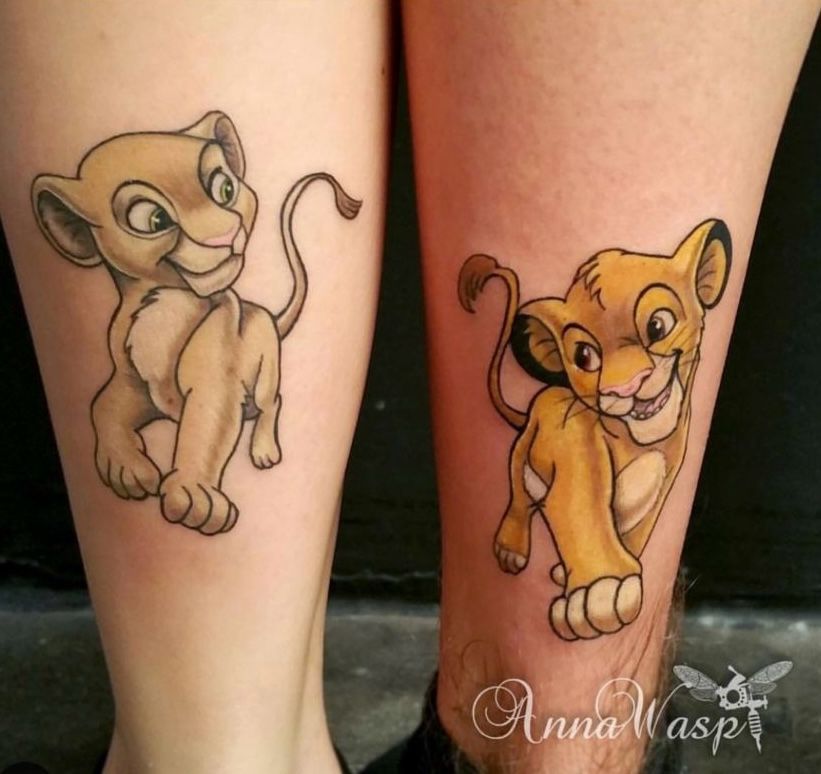 Two matching Simba and Nala tattoos on legs.