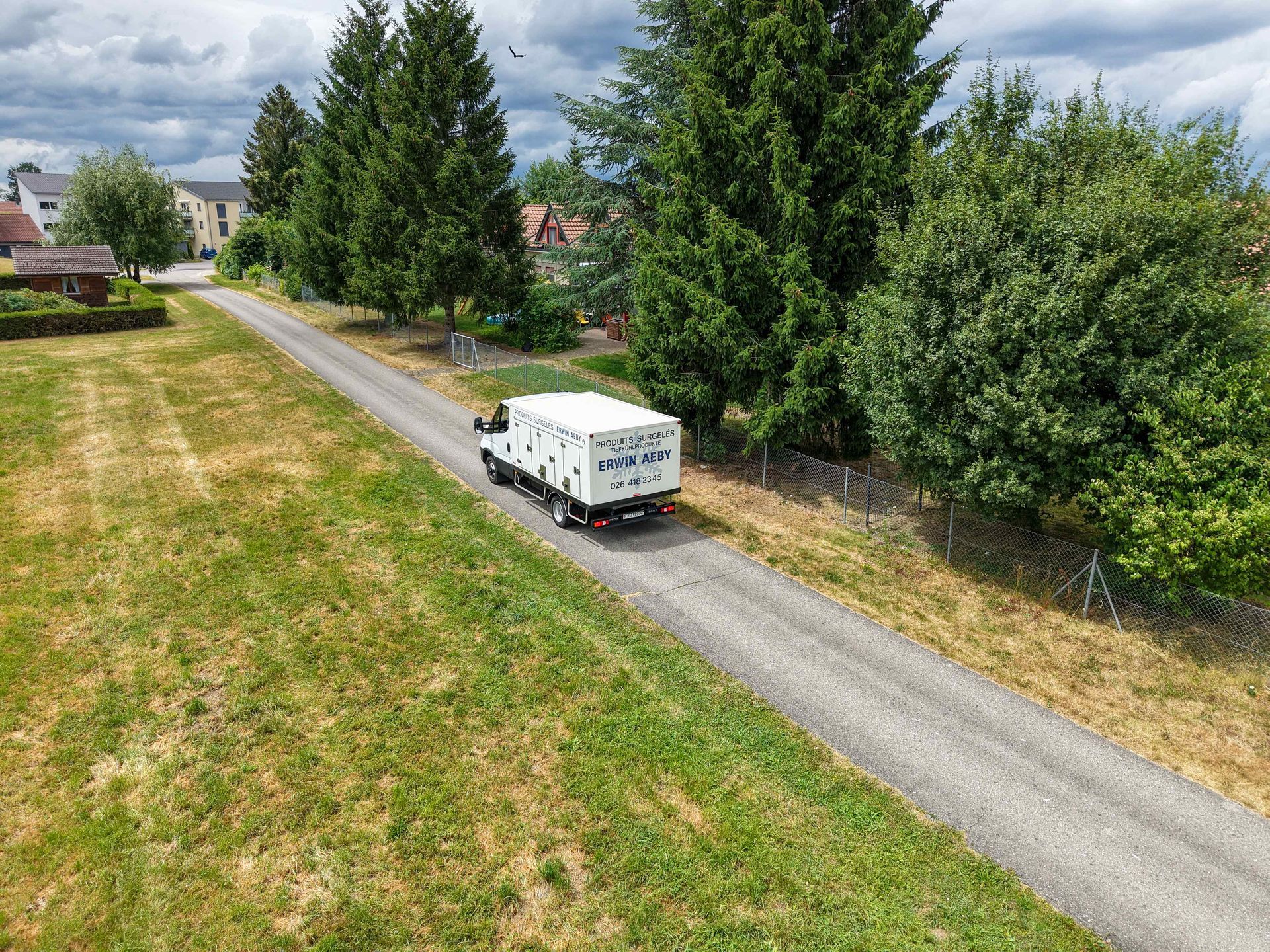 Une vue aérienne d'un camion roulant sur un chemin de terre.