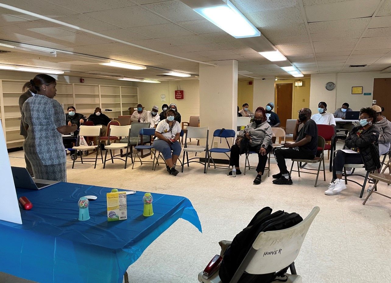 A group of people are sitting around a table in a room.