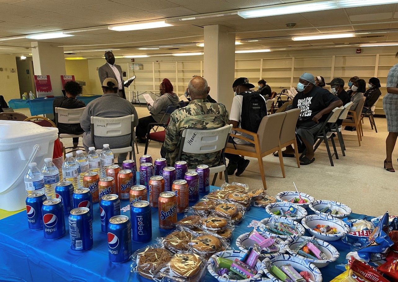 A group of people are sitting around a table with snacks and drinks.