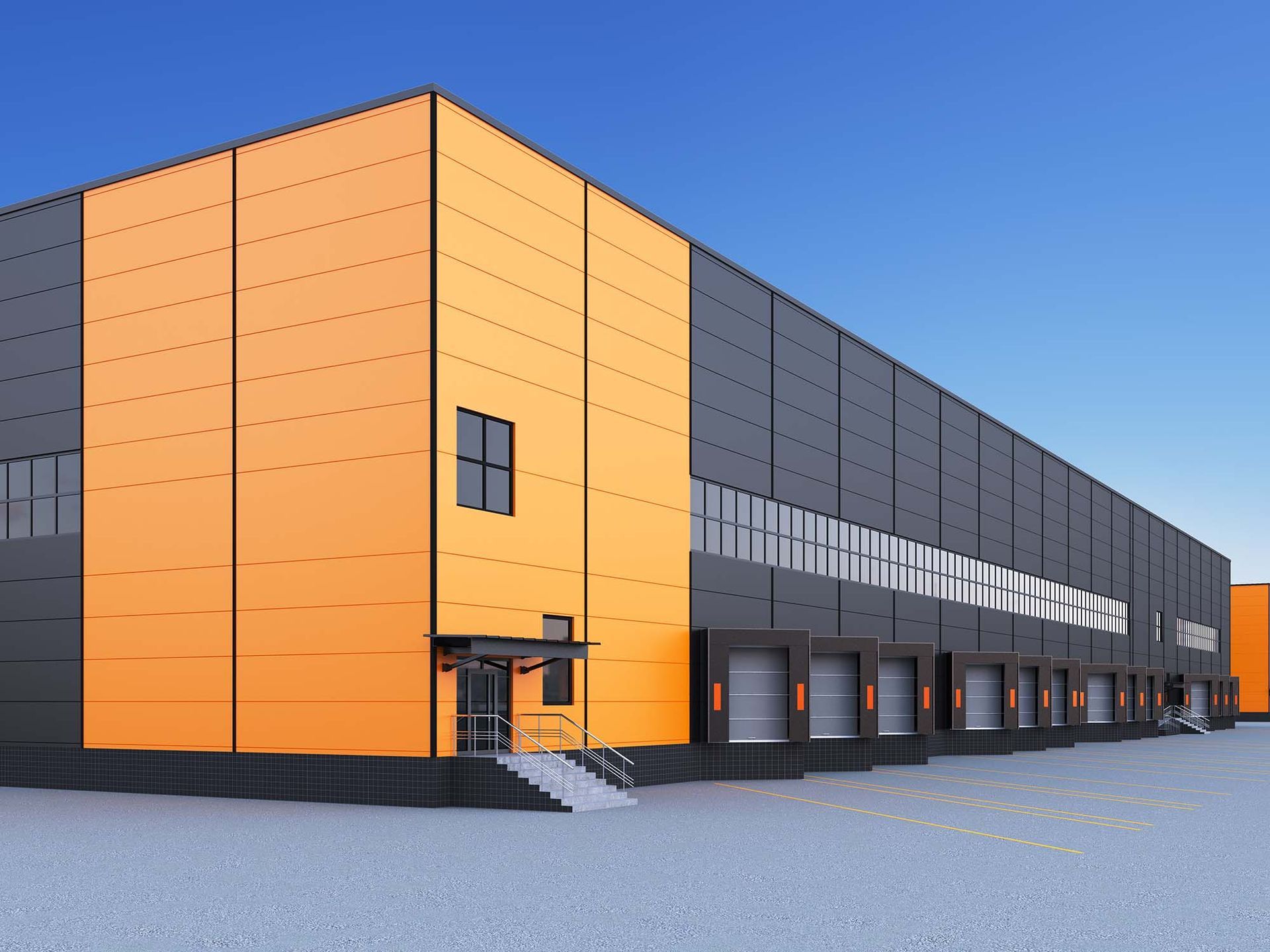 Modern industrial warehouse with orange and gray panels under a clear blue sky