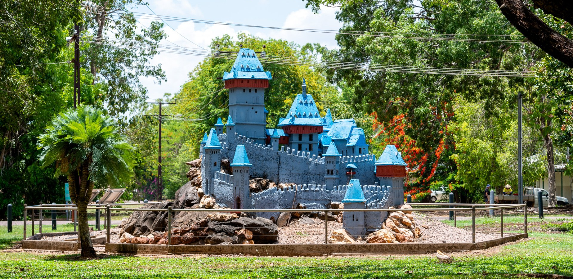A castle made out of lego bricks is sitting in the middle of a park.