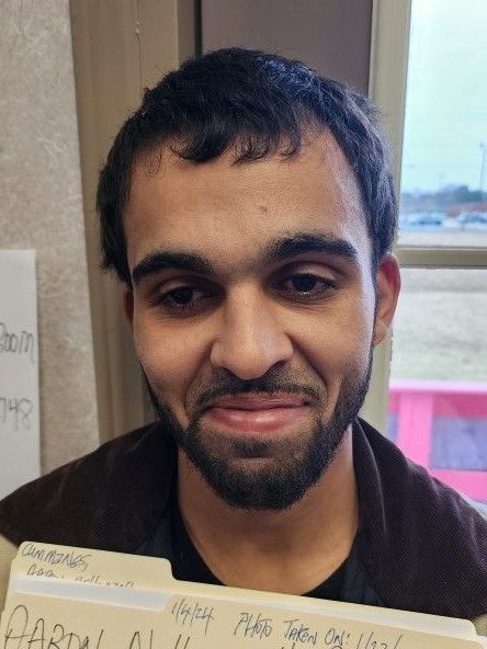 A man with a beard is smiling while holding a folder that says partial