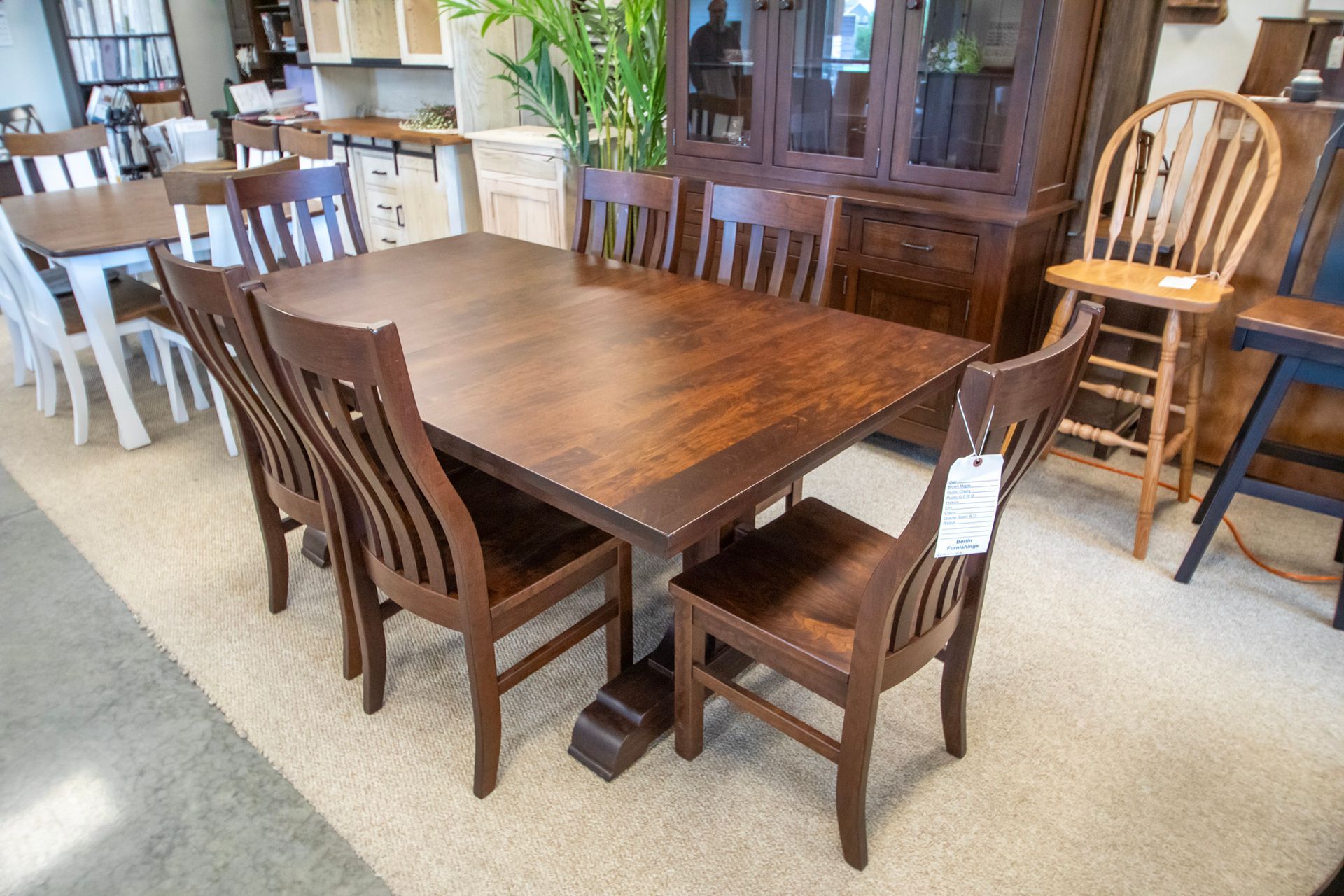 Dining room set with dark wood table and chairs in a showroom.