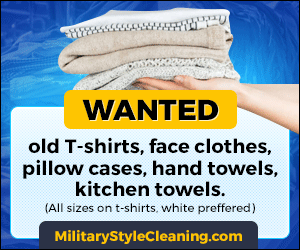 A person is holding a pile of clothes and a sign that says wanted