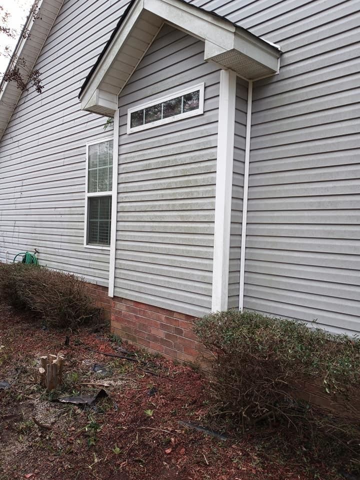 The side of a house with a window and a porch.