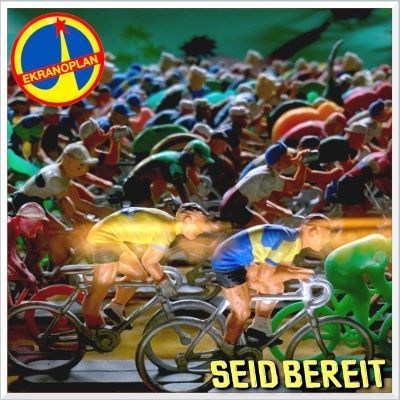 Un folto gruppo di statuine di ciclisti in plastica su una pista, con il logo 