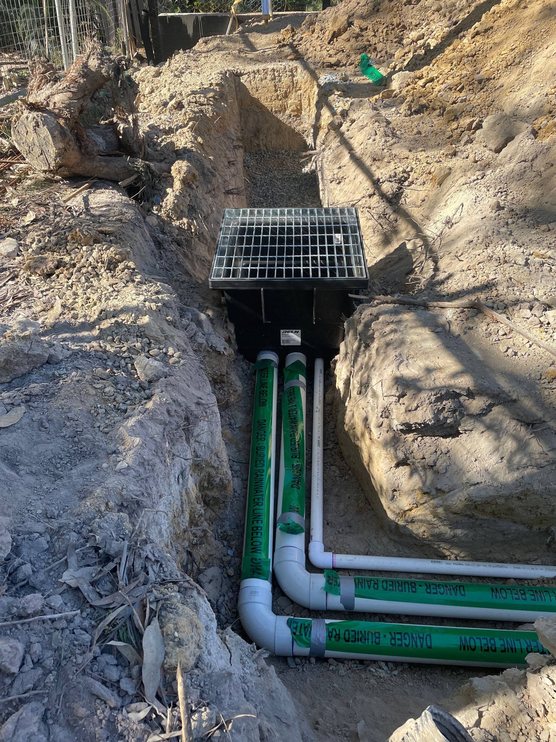 A bunch of pipes are being installed in the dirt.