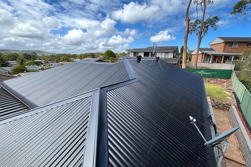 Black Roof In Cloudy Sky — Roofer in Lake Macquarie, NSW
