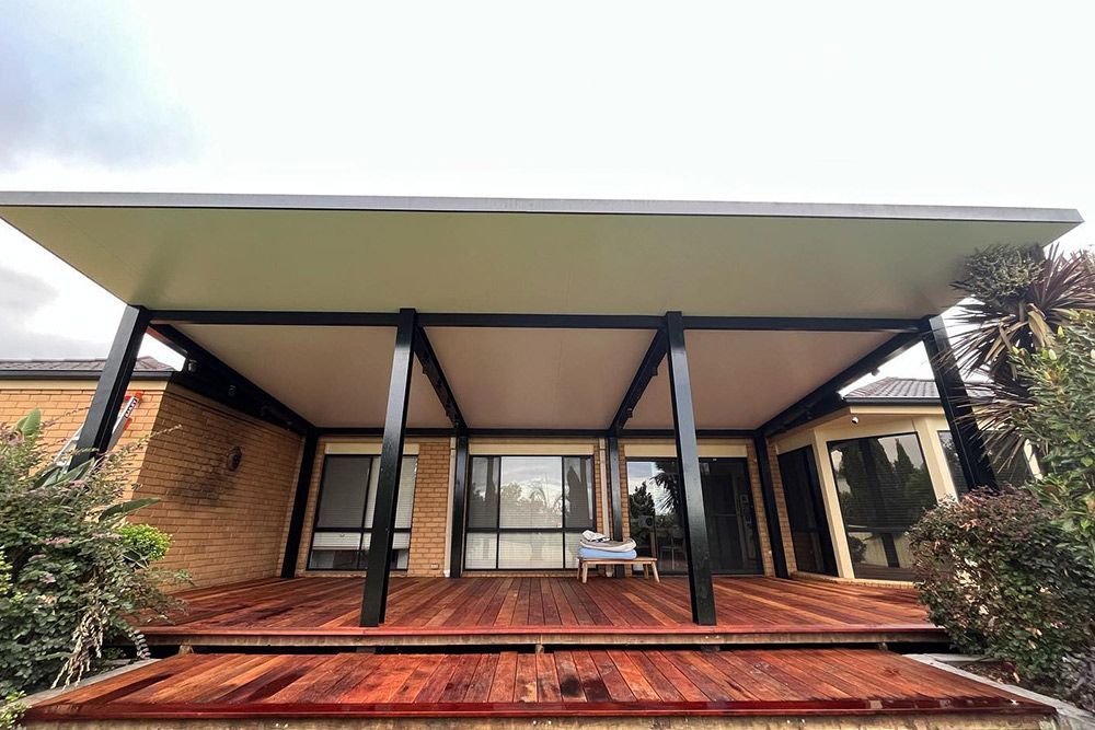 A house with a wooden deck and a covered patio.