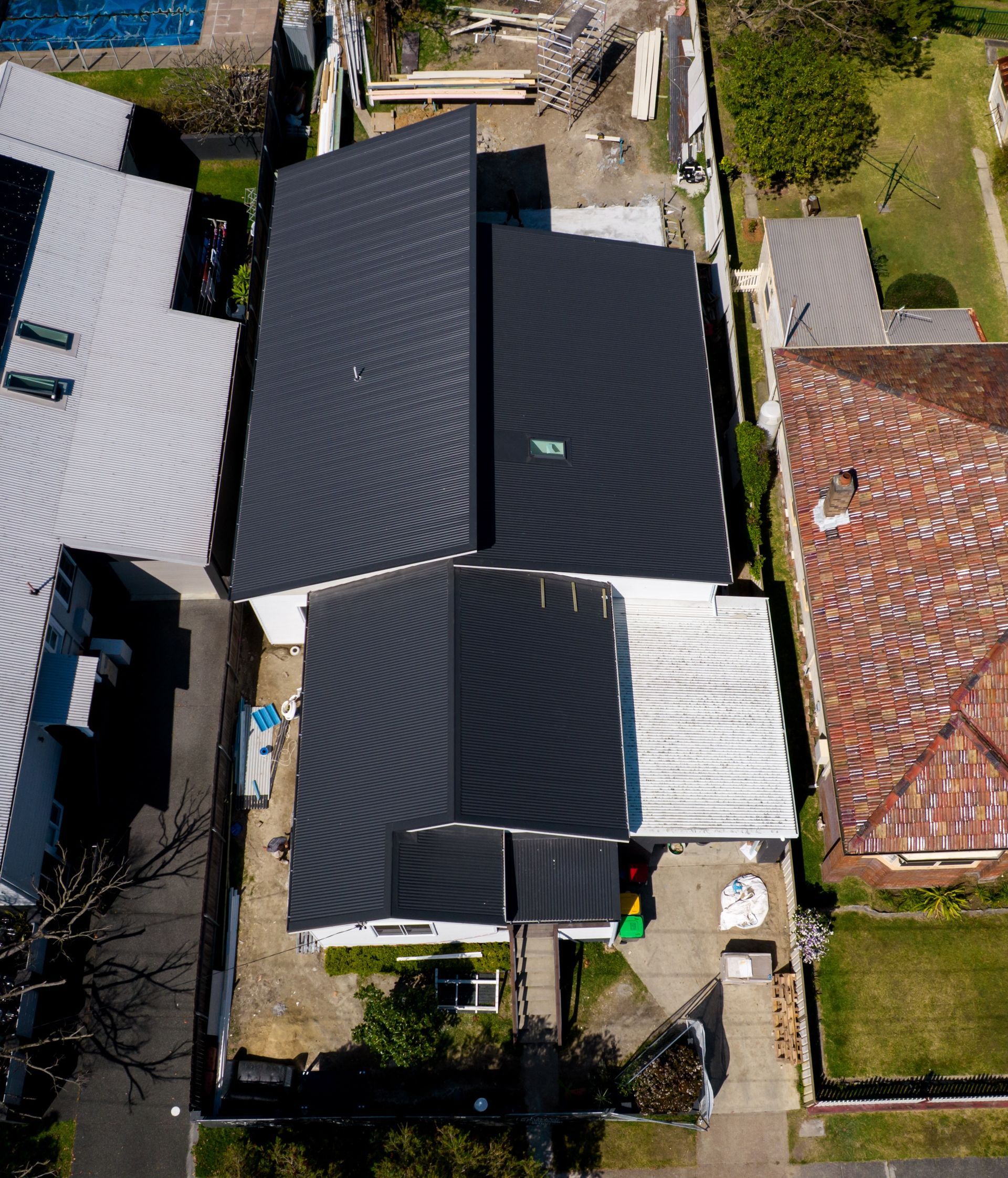 Workers on a Green Tiled Roof in a Sunny Setting — Roofing in Newcastle, NSW