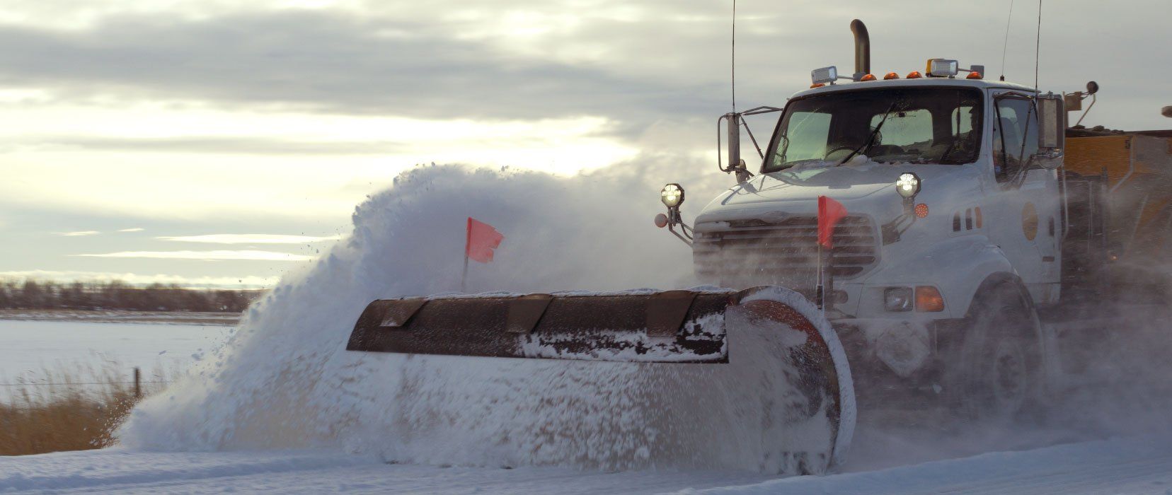Un chasse-neige déblaye la neige d'une route.
