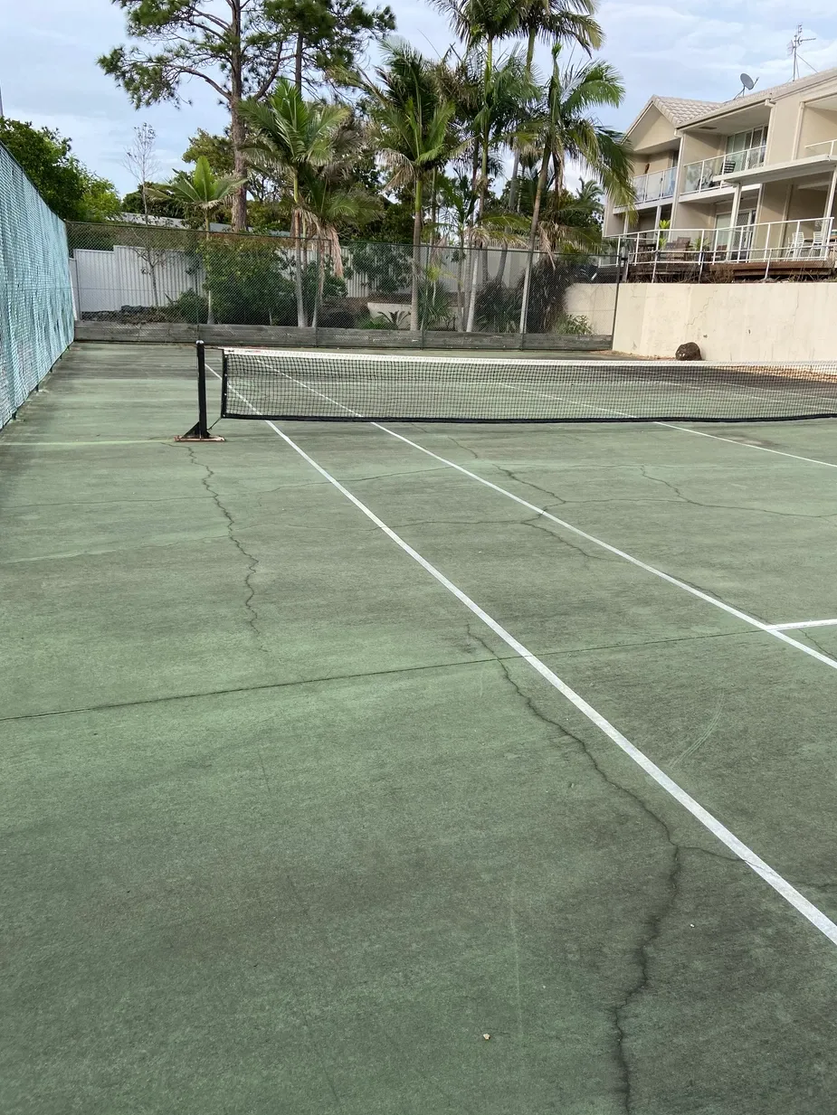 an image of a dirty tennis court in need of more gold coast pressure cleaning