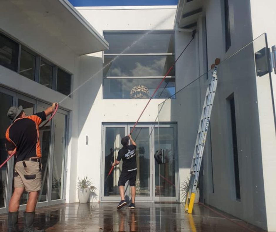 Get Wet Cleaning staff conducting  soft washing method for the delicate surfaces of a house
