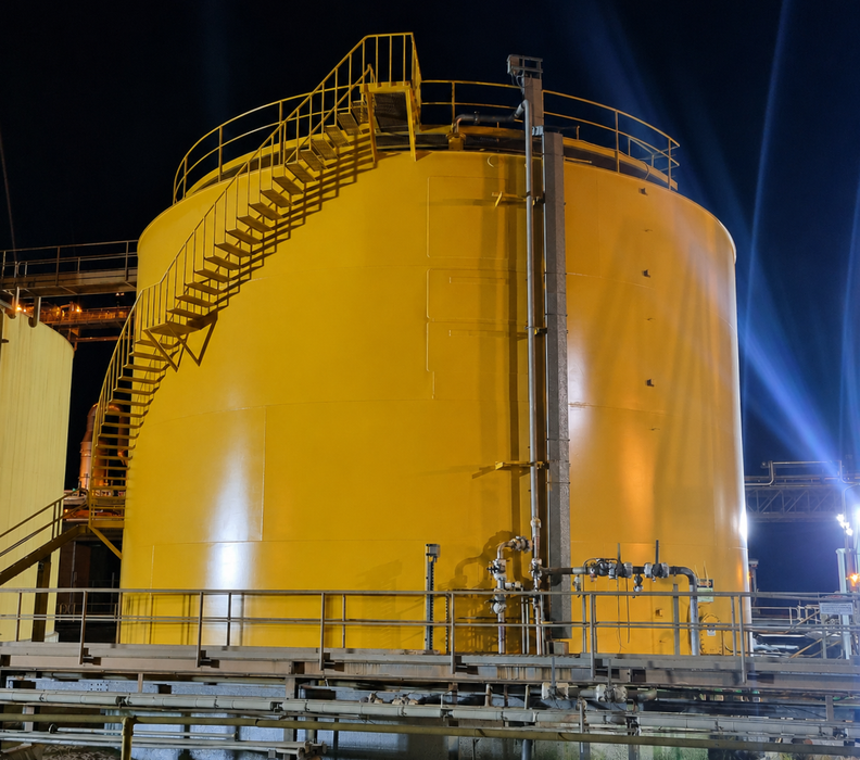 Large yellow industrial storage tank with metal stairs and railings at night — Sirocco Industrial in Pinelands, NT