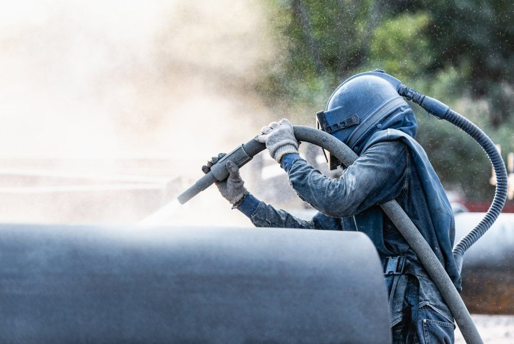 Person Sandblasting a Pipe — Sirocco Industrial in Pinelands, NT