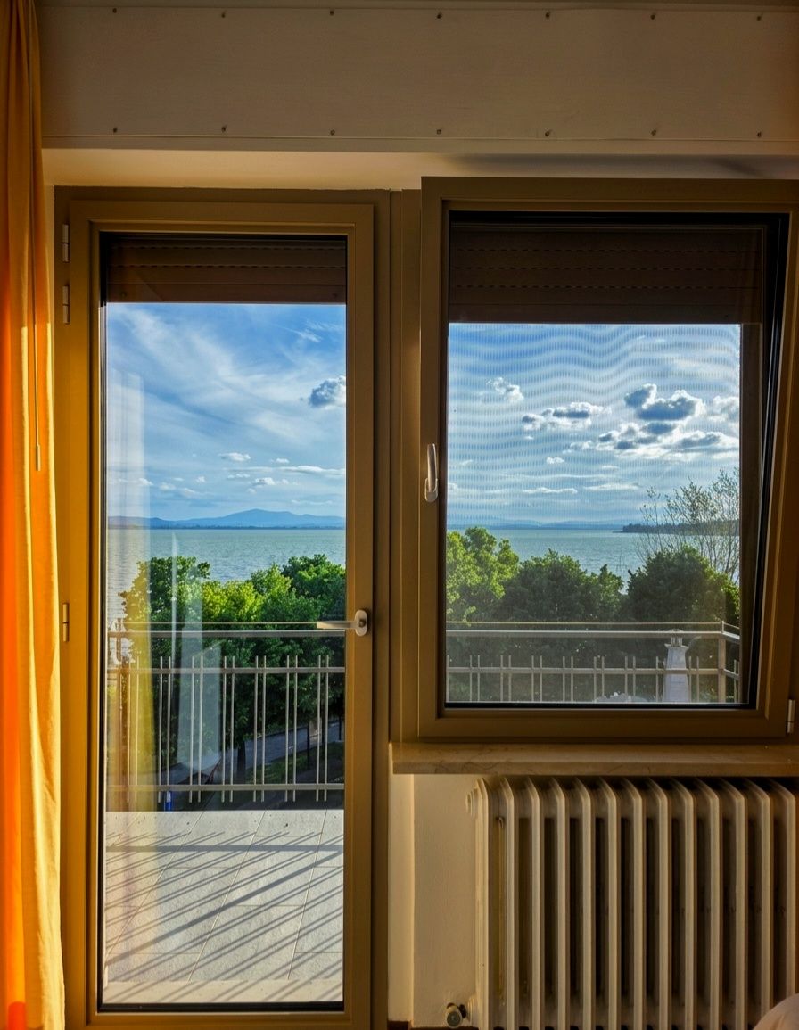 Terrazza esterna del caffè con fioriere, tenda da sole bianca e un'insegna con la scritta