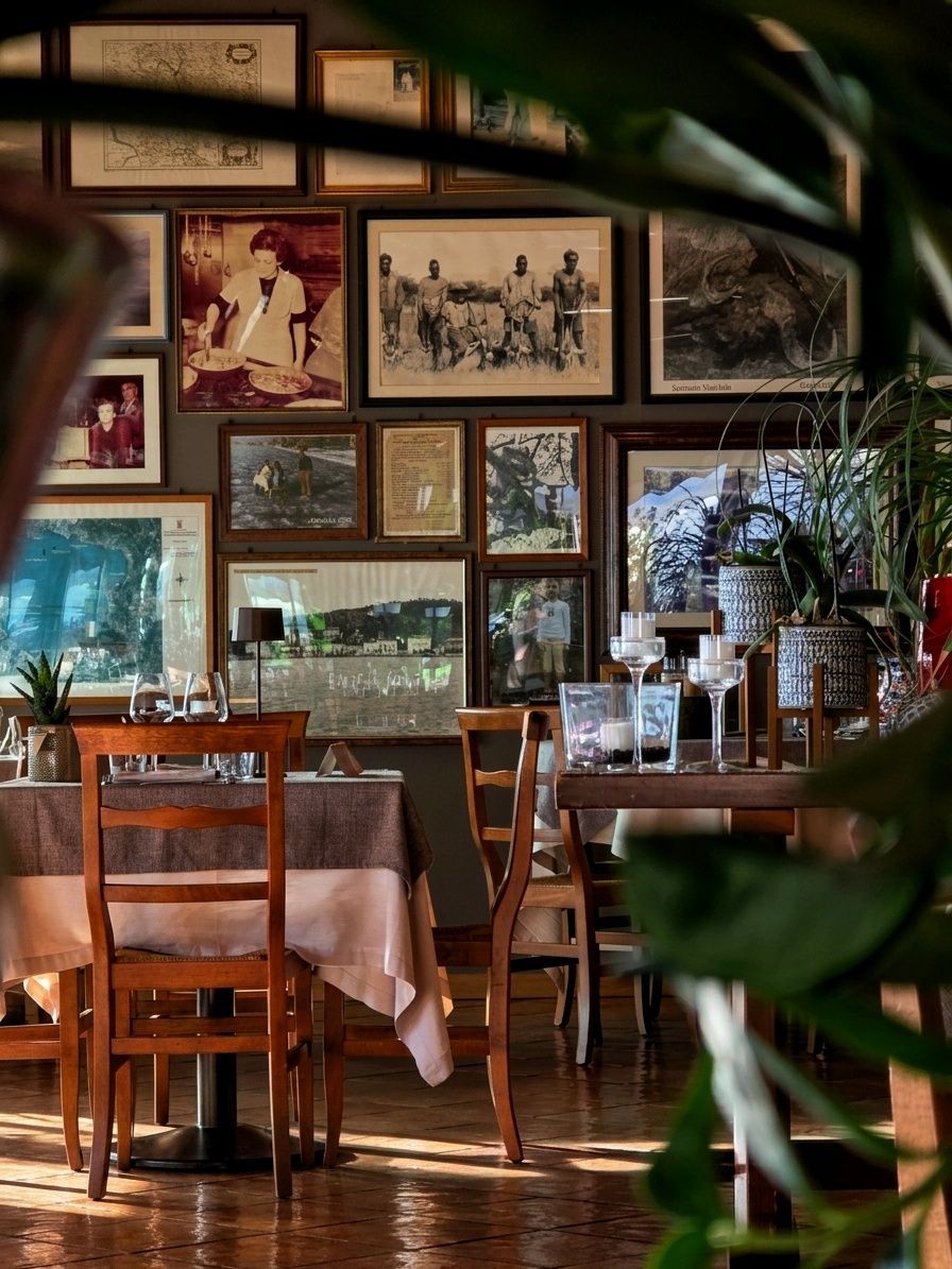 Ristorante all'aperto con tovaglie rosse, soffitto in legno e ampie finestre che si affacciano sul verde.