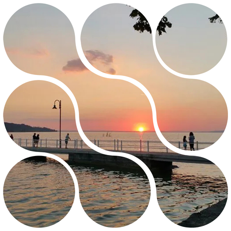 Tramonto su una passeggiata sul lungomare, con le persone che si stagliano contro il cielo arancione e l'acqua calma.