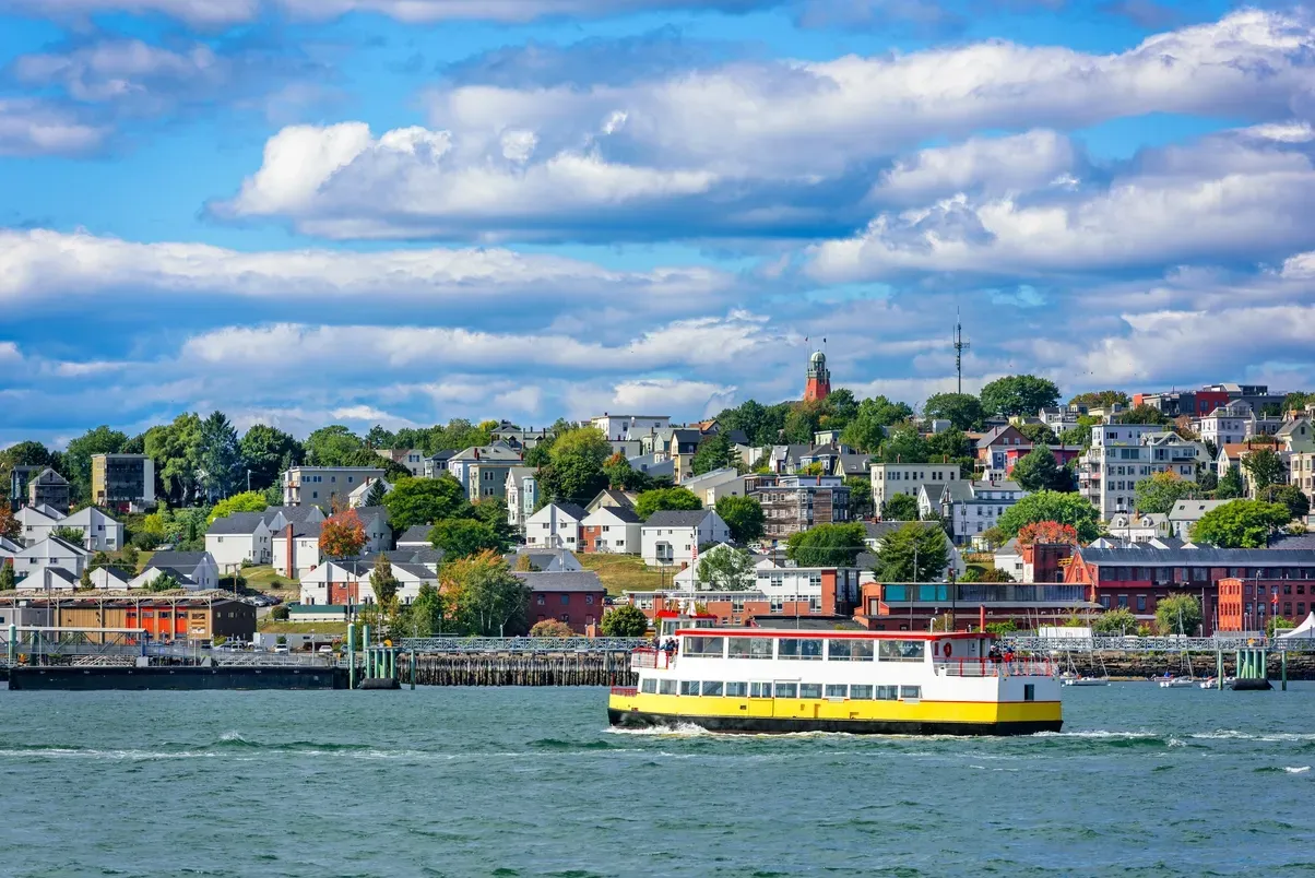 A yellow and white boat is floating on top of a body of water.