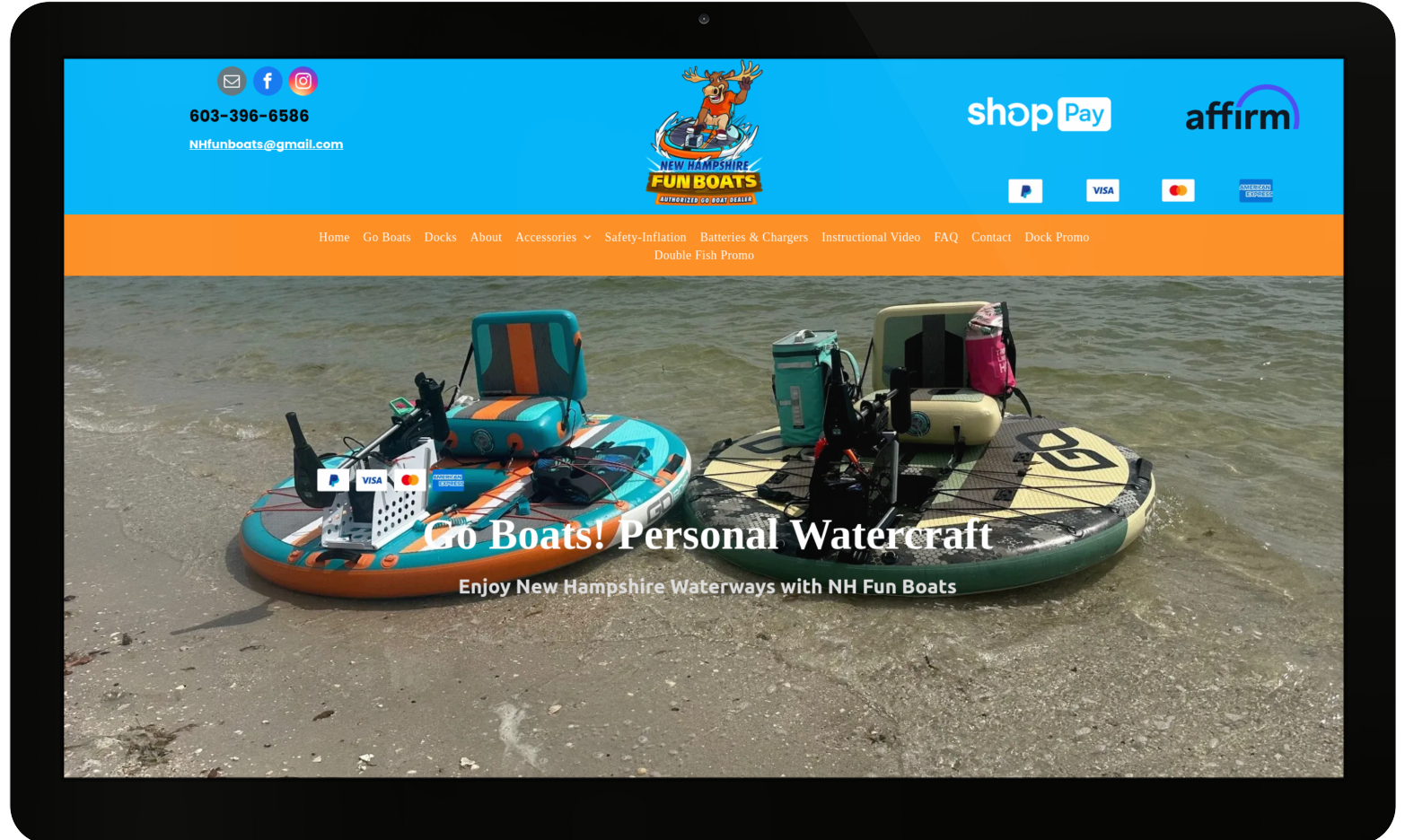 A computer screen shows two boats on the beach.