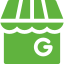 A green store with a white awning and the letter g on it.