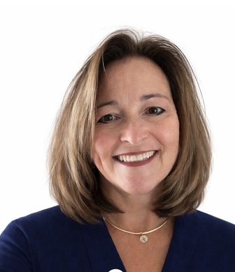 Smiling woman in a navy top against a white background