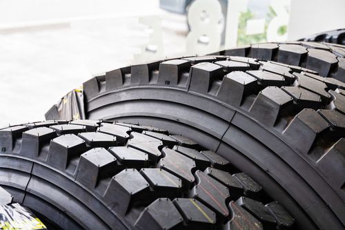 Close-up of two rugged black off-road tires with deep tread patterns