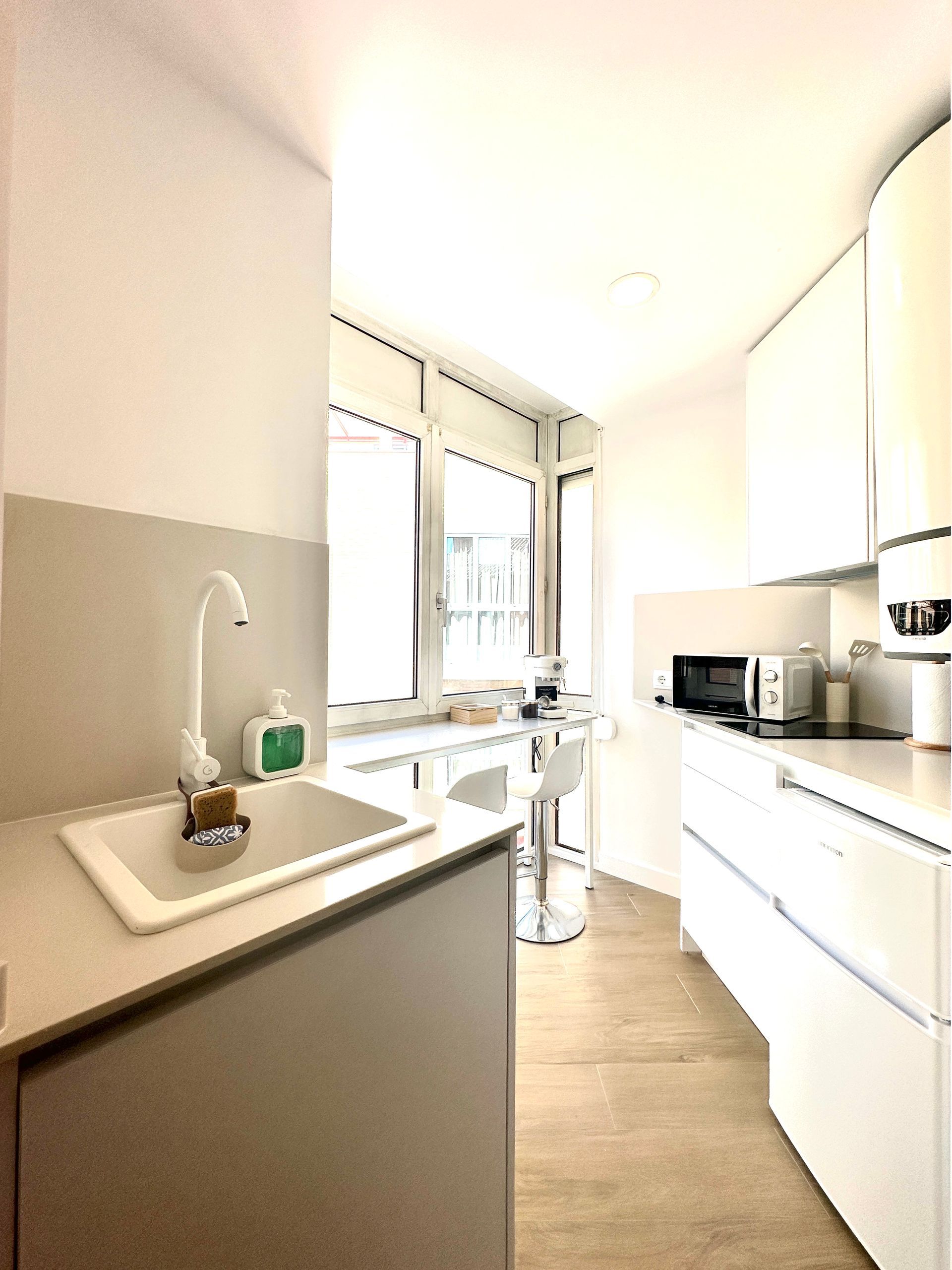 Una cocina con gabinetes blancos y un fregadero.