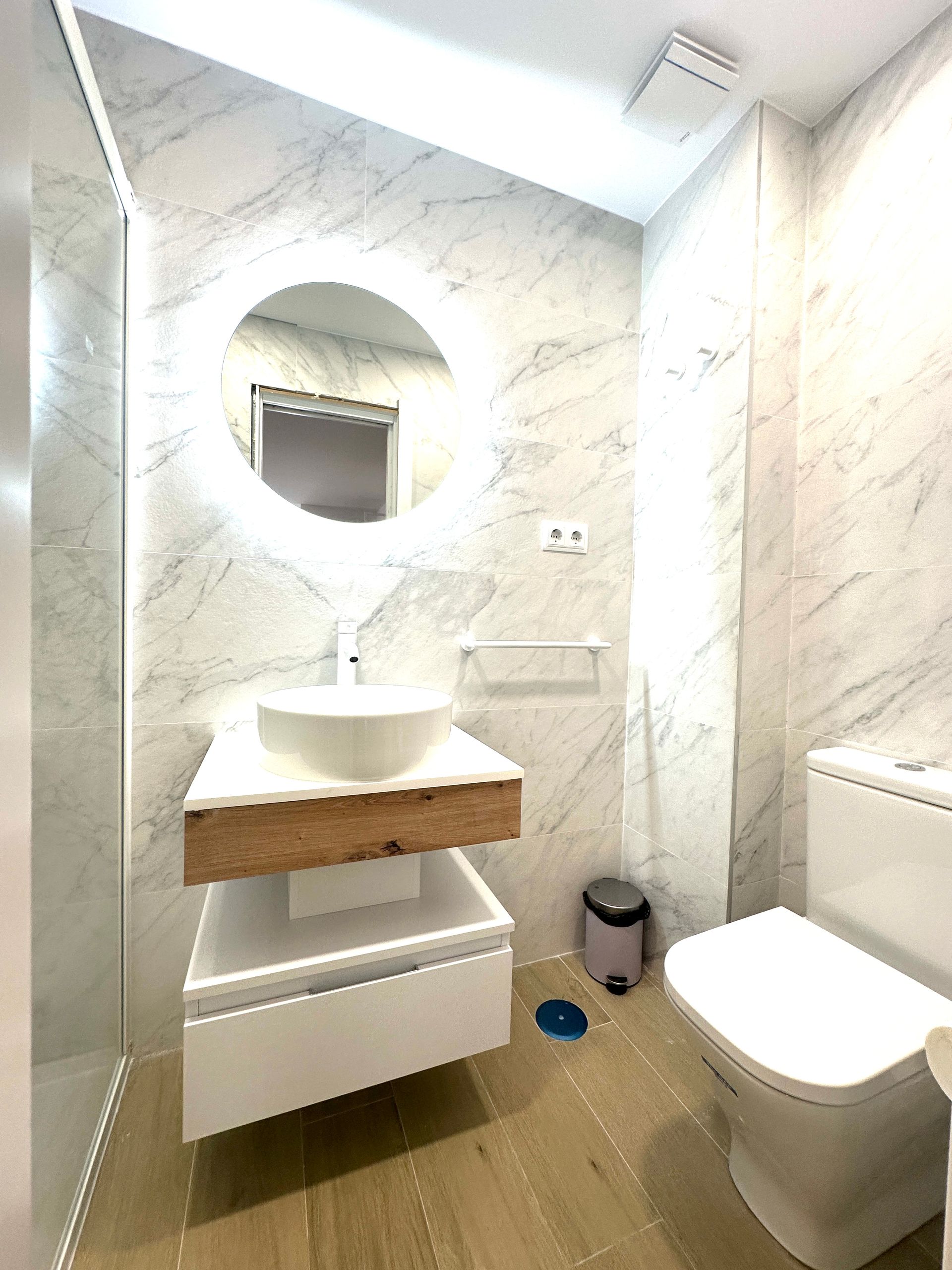 Un baño con lavabo, inodoro y espejo.
