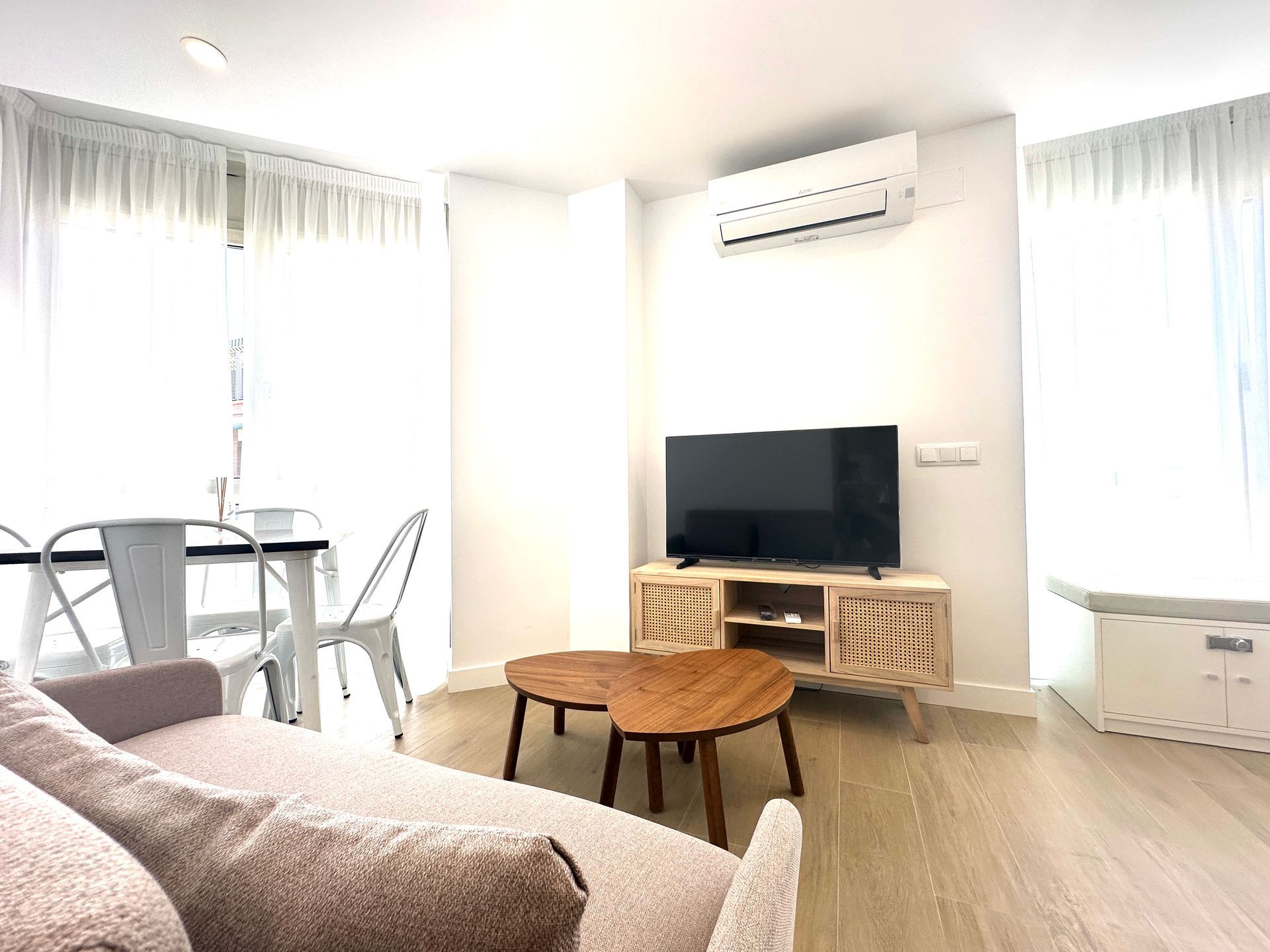 Una sala de estar con sofá, mesa y televisión.