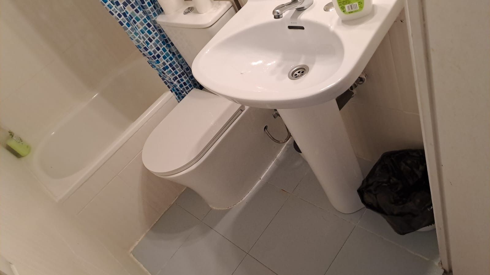 Baño con lavabo, inodoro, bañera y bote de basura.