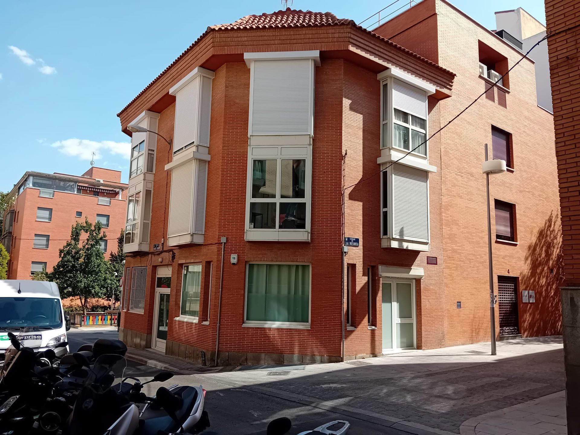 Un edificio de ladrillo con una motocicleta estacionada enfrente.