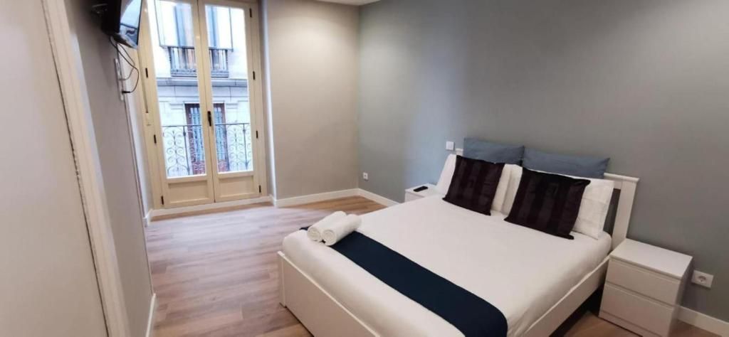 Un dormitorio con una cama, mesita de noche y televisión.