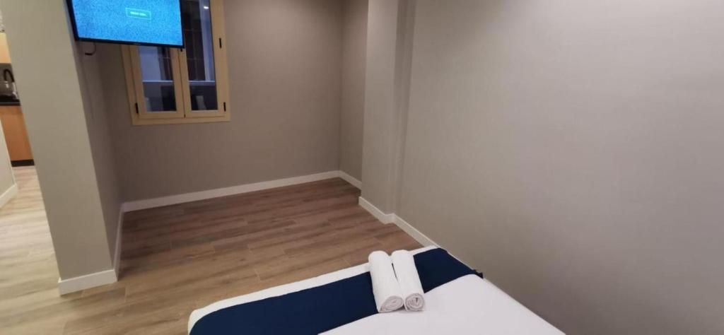 Un dormitorio con una cama y un televisor en la pared.