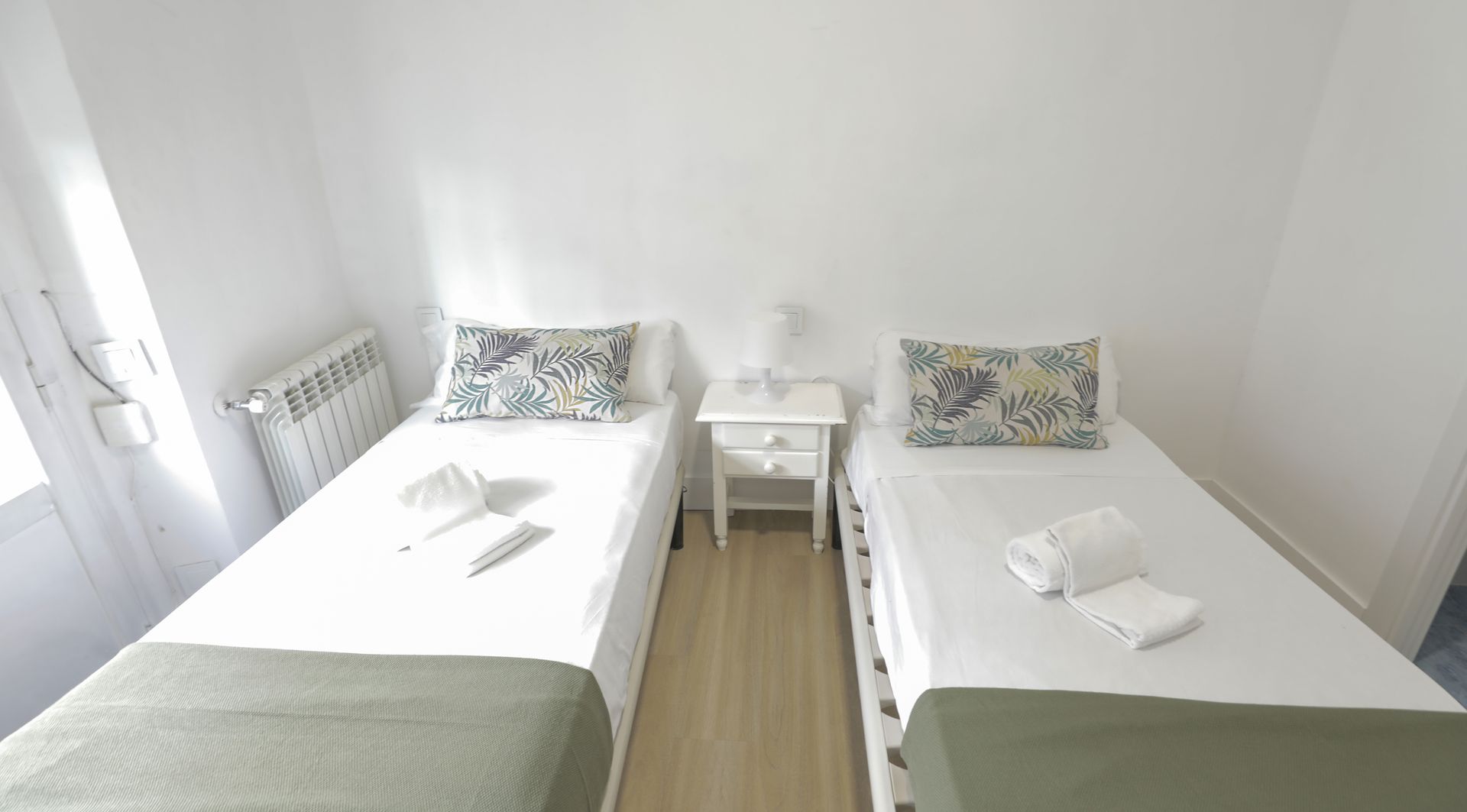 Un dormitorio con dos camas individuales y una mesita de noche.