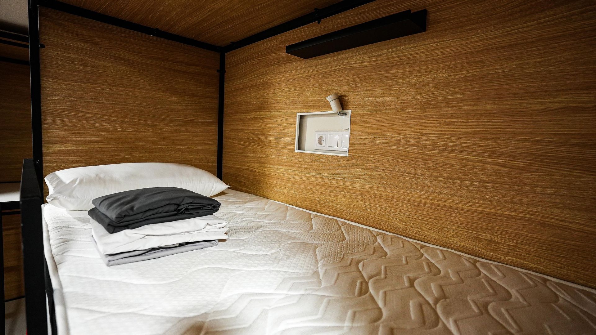 Una litera con colchón y almohadas en una habitación.